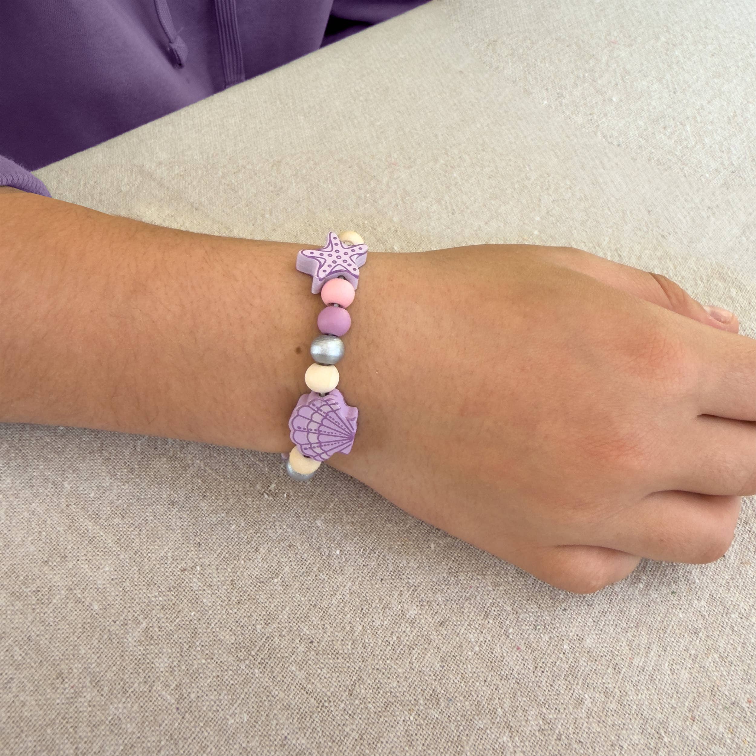 Child wearing handmade seashell bracelet