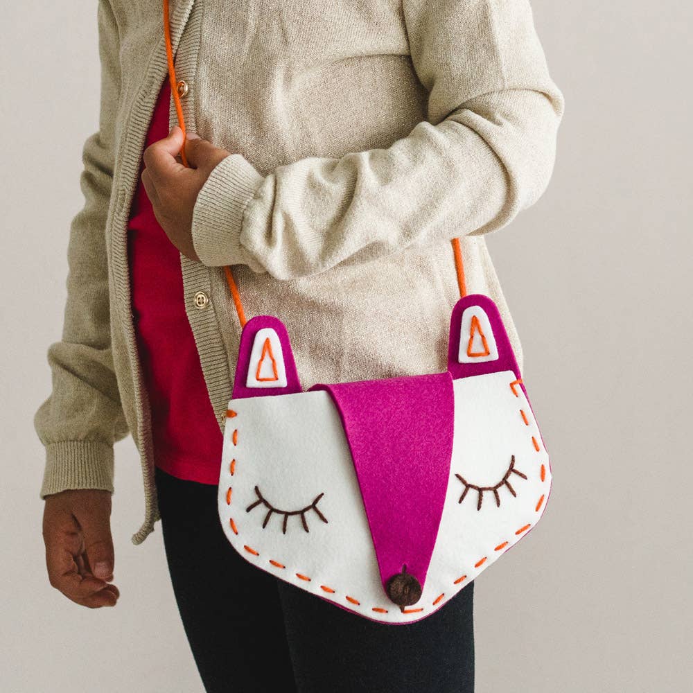 Child wearing finished fox bag from kids sewing kit
