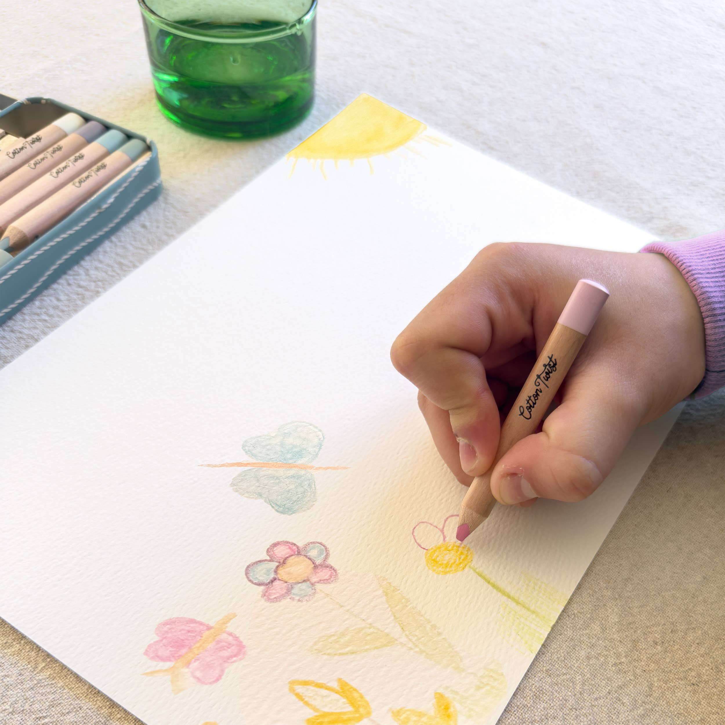 Child painting with watercolour pencil, wet-on-paper technique