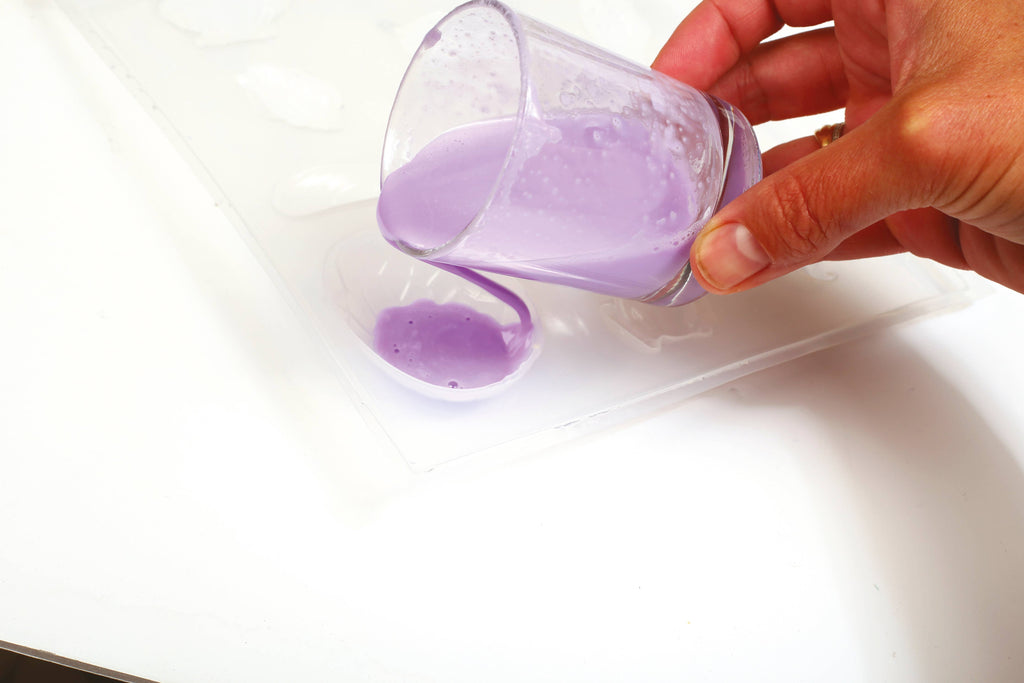 Pouring soap mixture into dinosaur mold