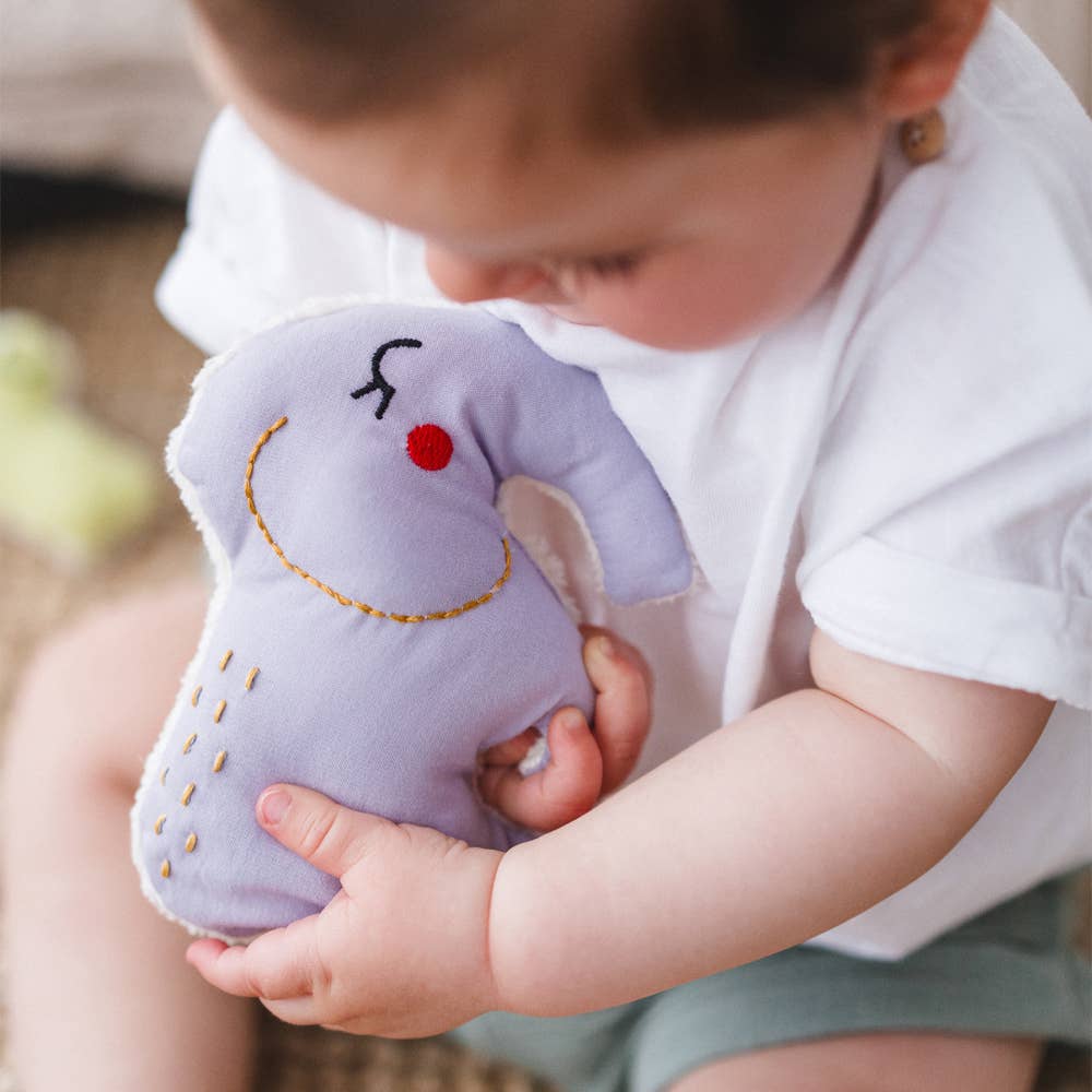 Baby playing with organic cotton elephant rattle