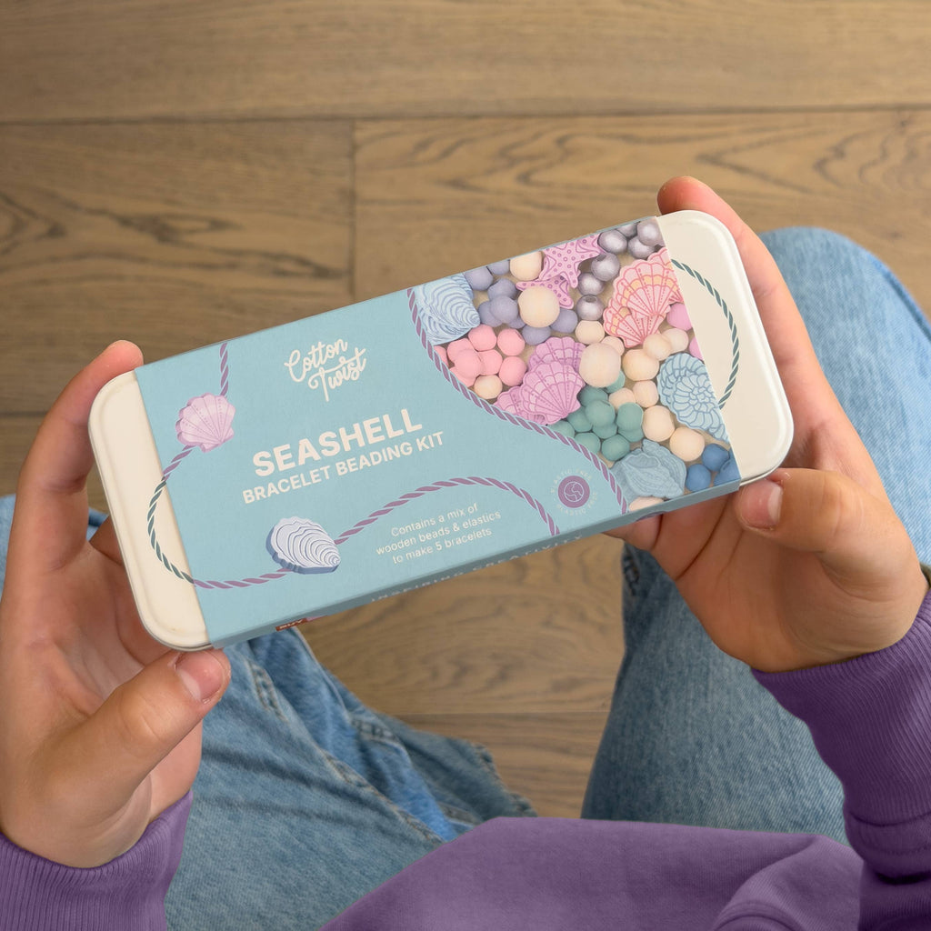 Person holding Seashell Bracelet Kit tin