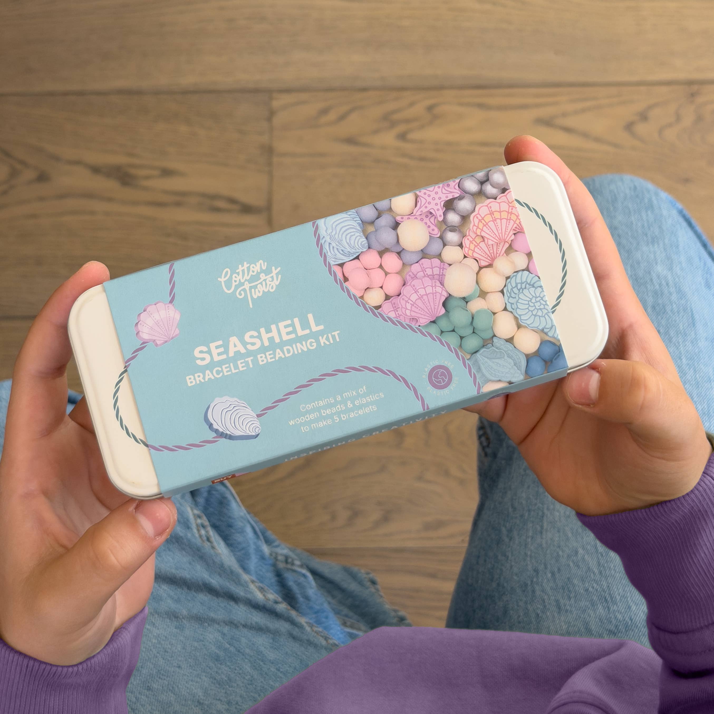 Person holding Seashell Bracelet Kit tin