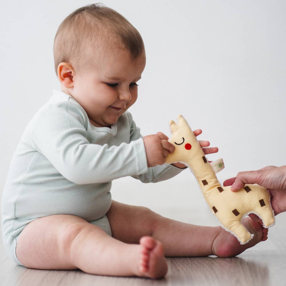 Baby playing with GOTS certified organic giraffe rattle