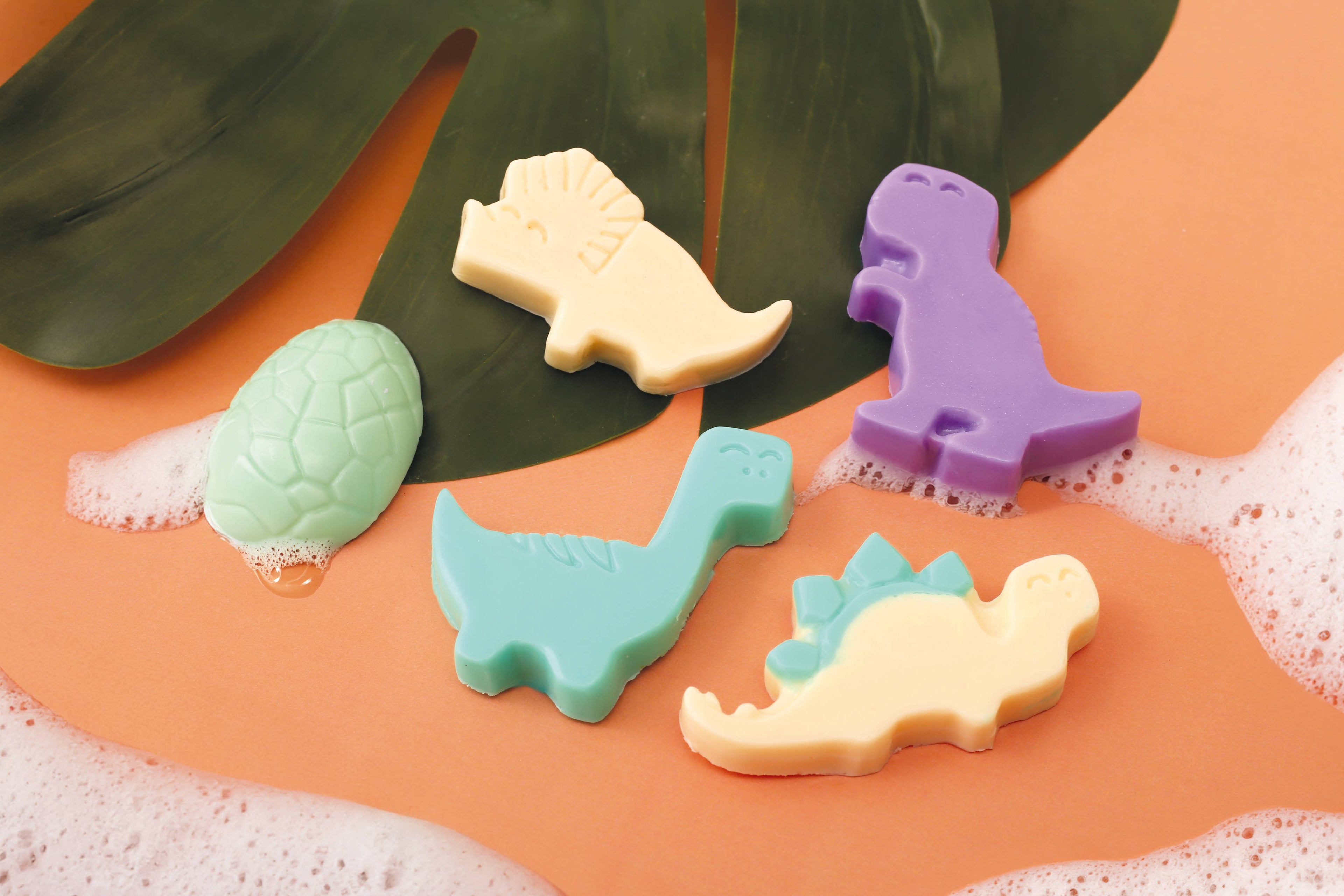 Dinosaur-shaped soaps on leaf background
