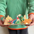 Child holding finished dinosaur wooden craft kit