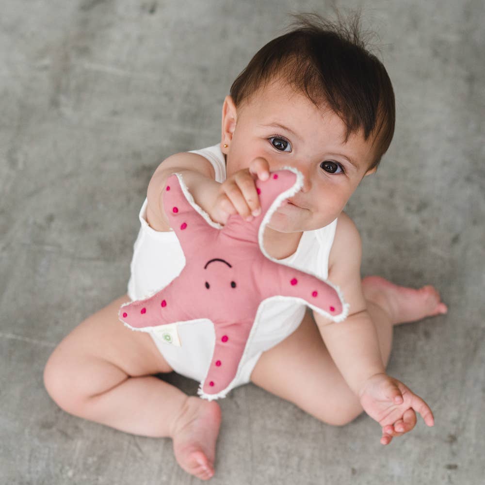 Baby holding organic cotton starfish rattle