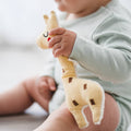 Baby playing with organic cotton giraffe rattle